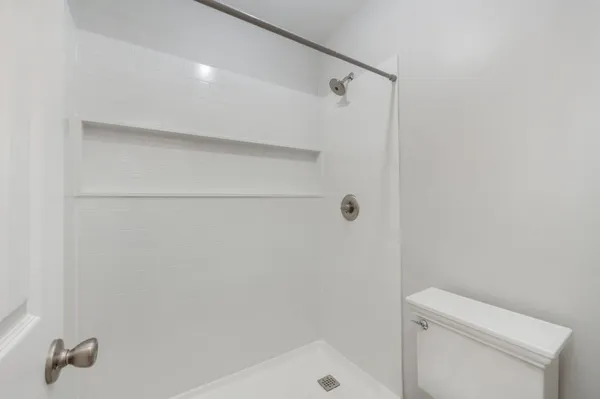 a bathroom with a shower and toilet