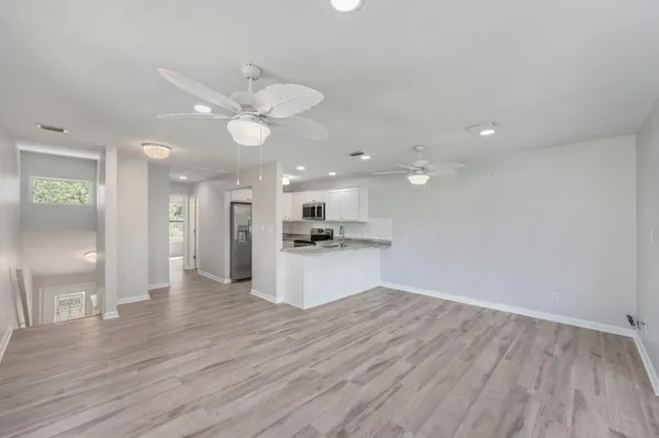 a view of kitchen with granite countertop cabinets and refrigerator