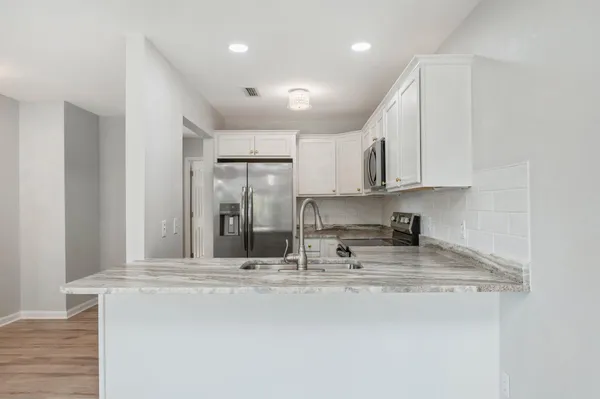 a view of kitchen with sink and refrigerator