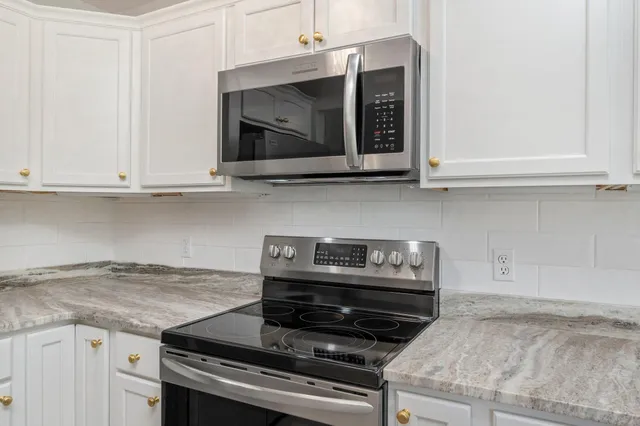a kitchen with granite countertop a stove and a microwave