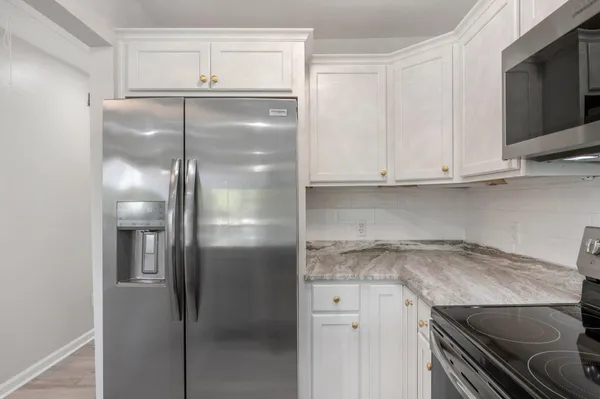 a kitchen with stainless steel appliances granite countertop a refrigerator and a microwave