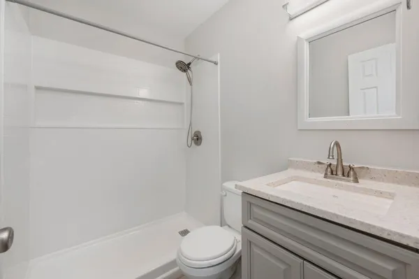 a bathroom with a sink a toilet and shower