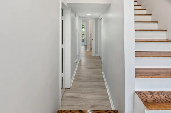 a view of a hallway with wooden floor and entryway