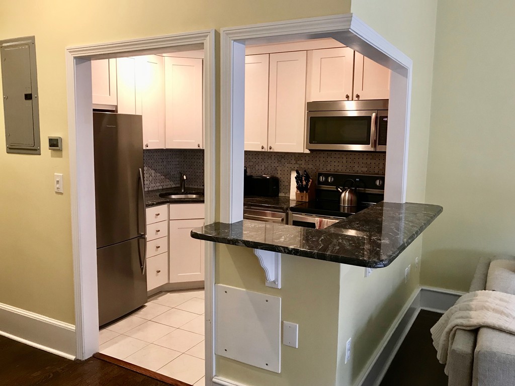 241 Beacon Street, Unit 3 Boston, MA 02116 - Photo 6 of 17 a kitchen with stainless steel appliances granite countertop a sink and a refrigerator