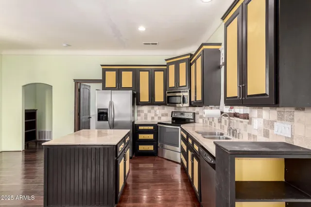 a kitchen with a sink refrigerator and cabinets