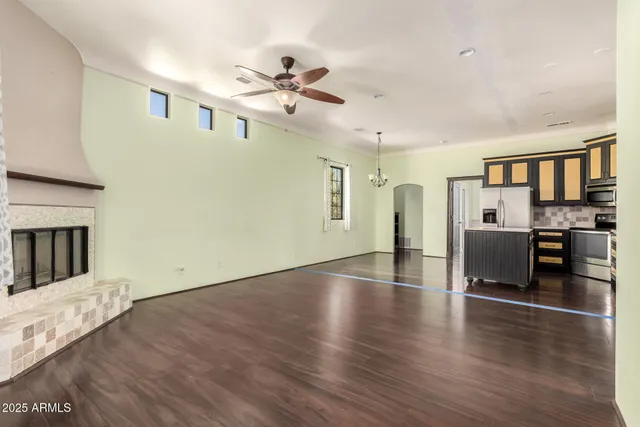 a view of a kitchen with furniture a ceiling fan and wooden floor