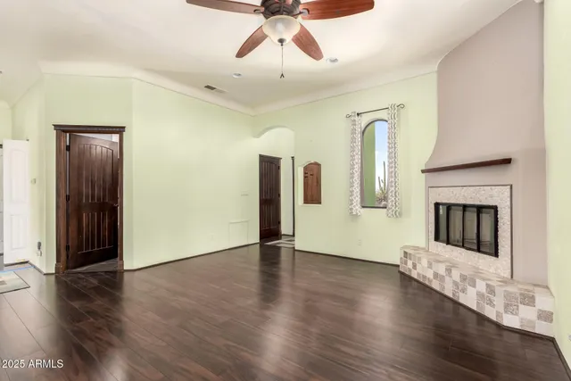 a view of a livingroom with wooden floor and a fireplace