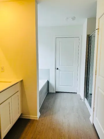 a view of an empty room and wooden floor