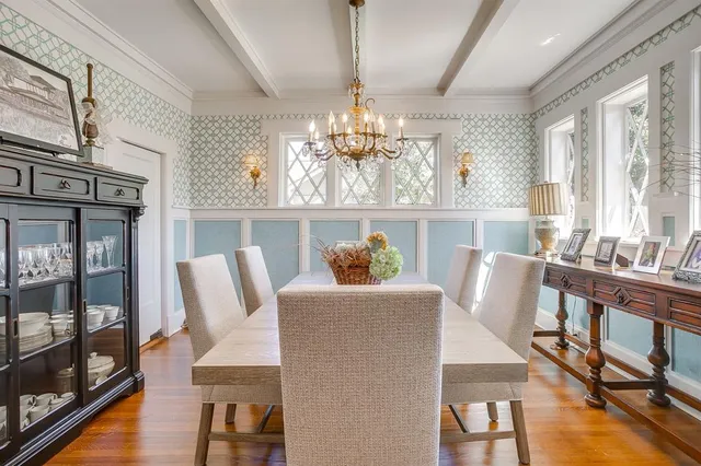 a dining room with furniture a chandelier and wooden floor