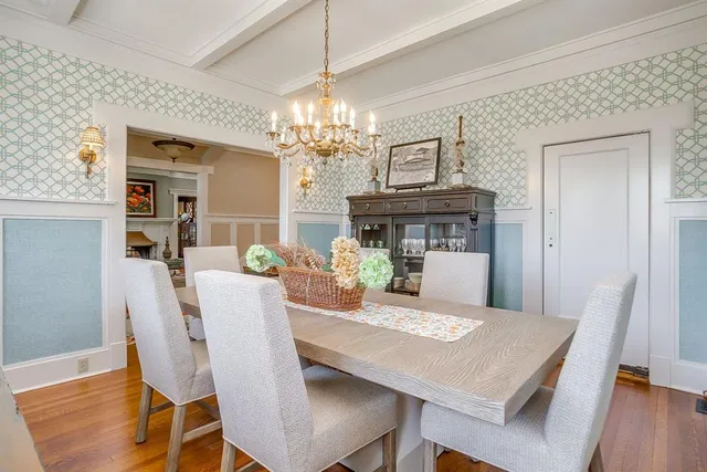 a view of a dining room with furniture a chandelier and wooden floor