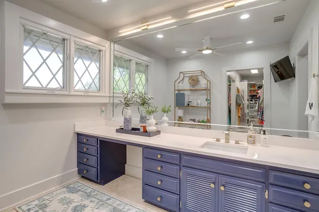 a spacious bathroom with a granite countertop sink a large mirror and a window