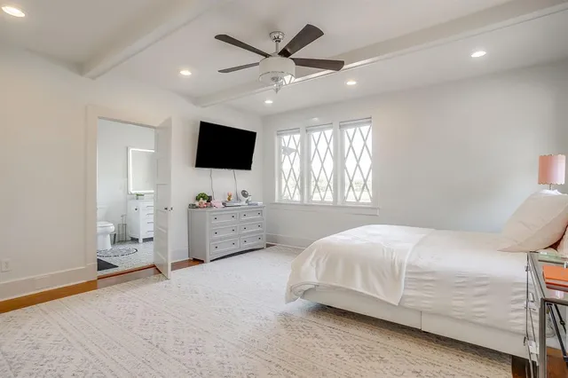 a bedroom with a bed window and a flat screen tv