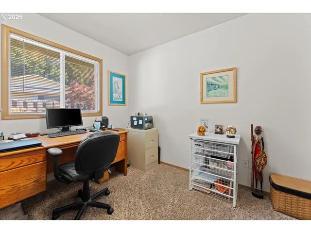 a view of a workspace with furniture and a window