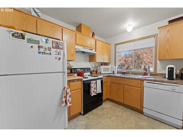 a kitchen with stainless steel appliances granite countertop a refrigerator sink and cabinets