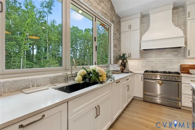 a kitchen with stainless steel appliances white cabinets and a large window