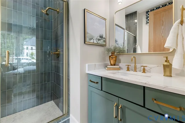 a bathroom with a granite countertop sink a mirror and shower