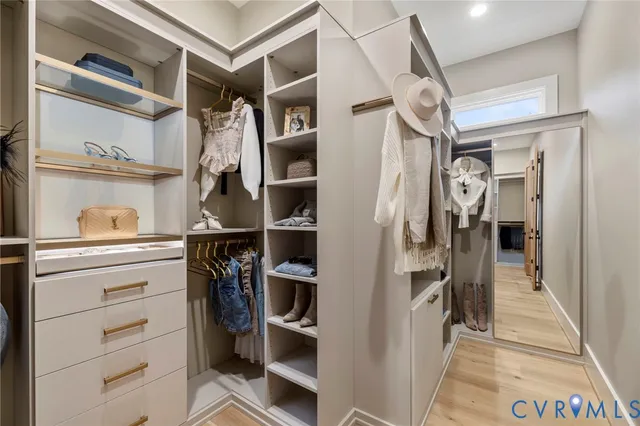 a view of walk in closet with clothes and shoes
