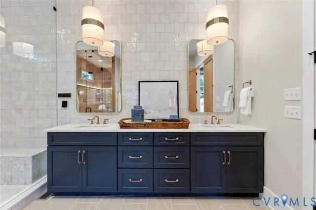 a bathroom with a granite countertop double vanity sink and a mirror
