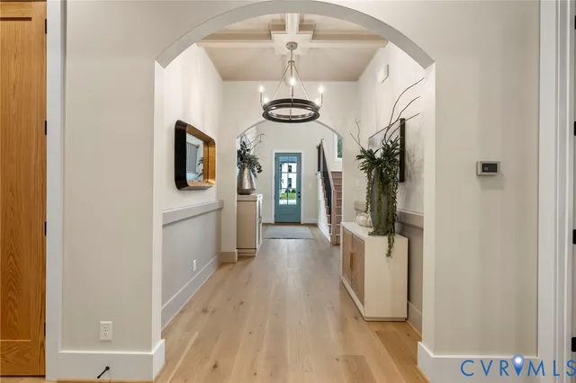 a view of a hallway with wooden floor and staircase