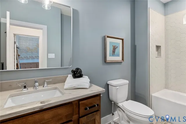 a bathroom with a granite countertop toilet sink and mirror