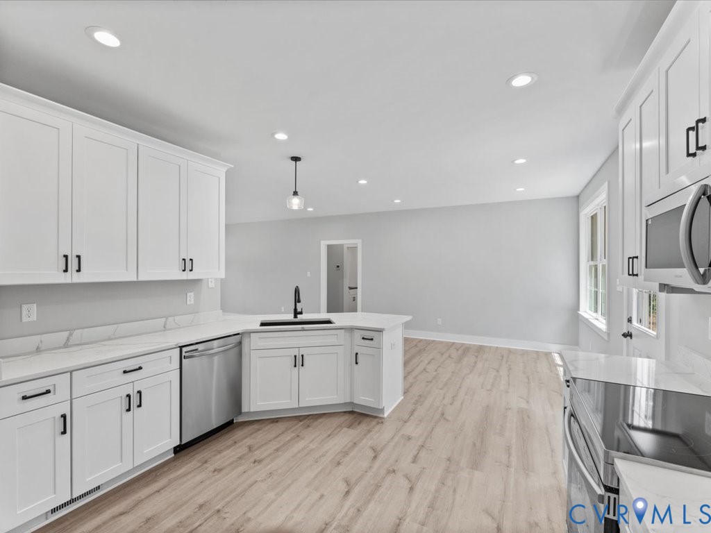 517 Frenchs Store Road Cumberland, VA 23040 - Photo 13 of 22 a kitchen with a sink wooden floor and white cabinets