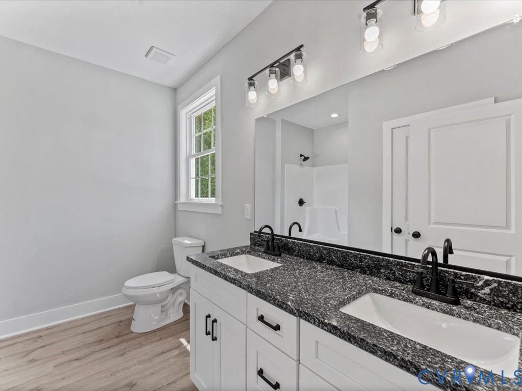 517 Frenchs Store Road Cumberland, VA 23040 - Photo 19 of 22 a bathroom with a granite countertop sink a toilet and a mirror