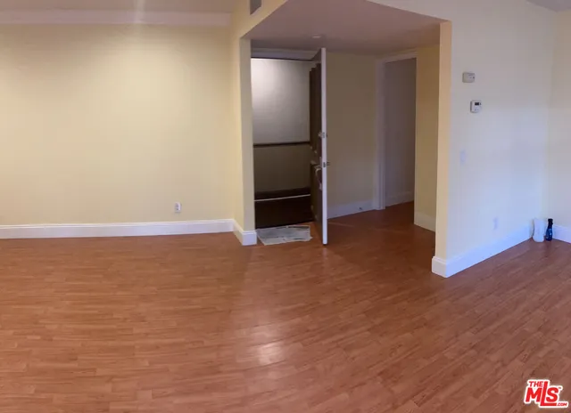 an empty room with wooden floor & closet