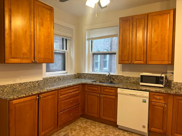 a kitchen with stainless steel appliances granite countertop wooden cabinets a sink and dishwasher