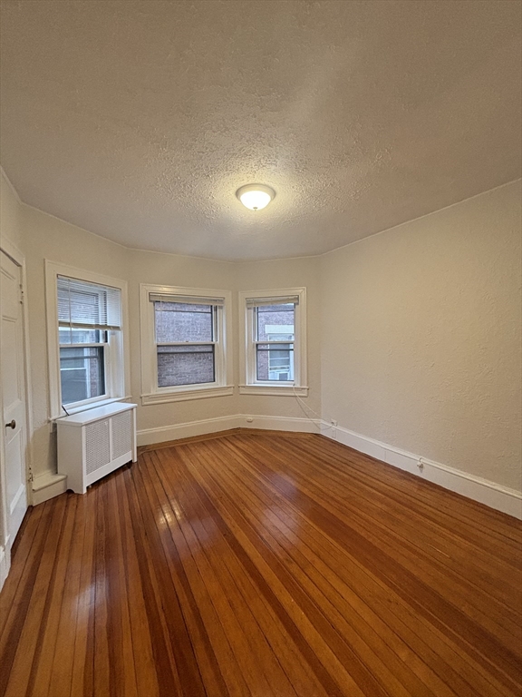 6 Beals Street, Unit 2 Brookline, MA 02446 - Photo 7 of 9 wooden floor in an empty room with a window