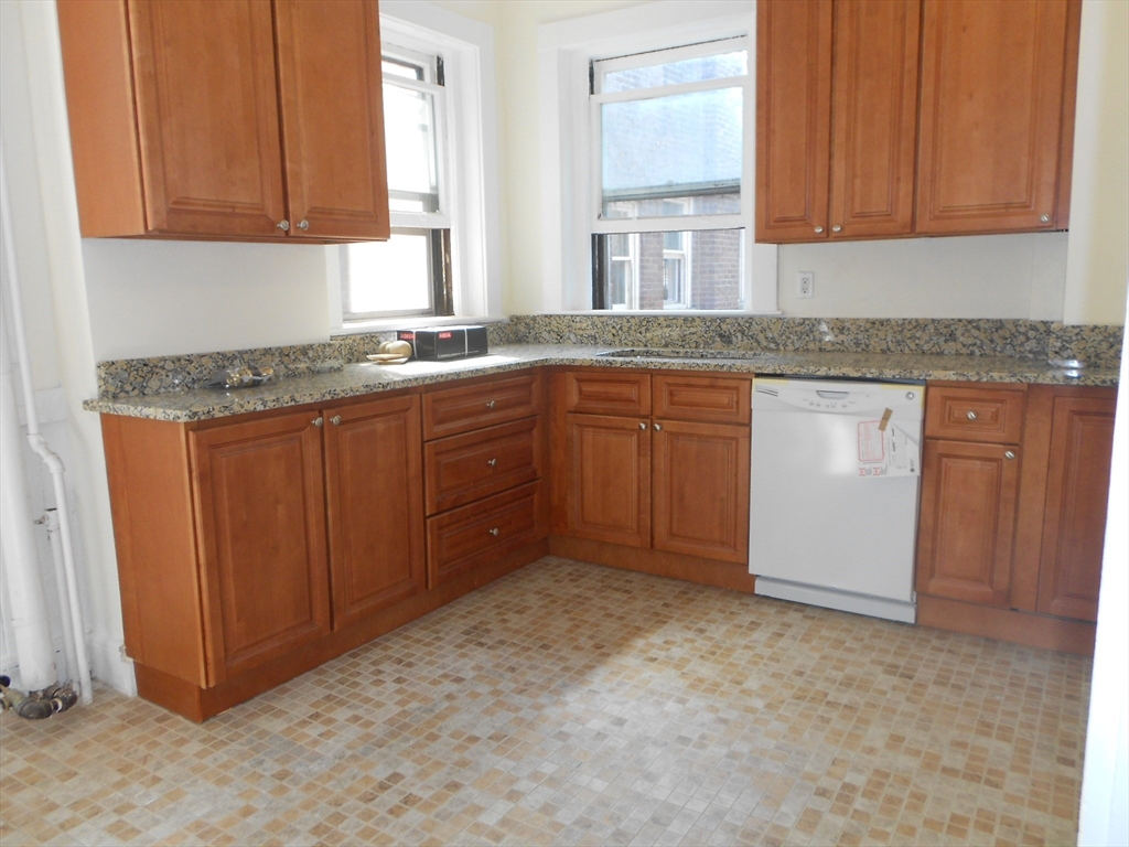 6 Beals Street, Unit 2 Brookline, MA 02446 - Photo 8 of 8 a kitchen with granite countertop cabinets and window
