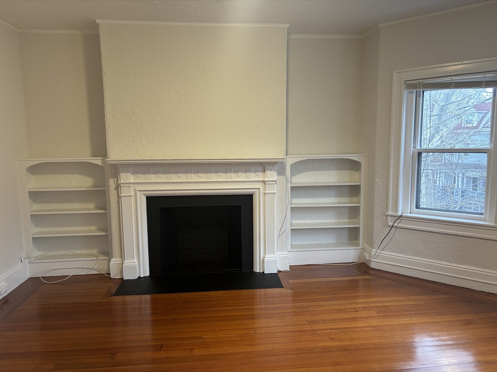 6 Beals Street, Unit 2 Brookline, MA 02446 - Photo 9 of 9 a view of a livingroom with a fireplace wooden floor and window