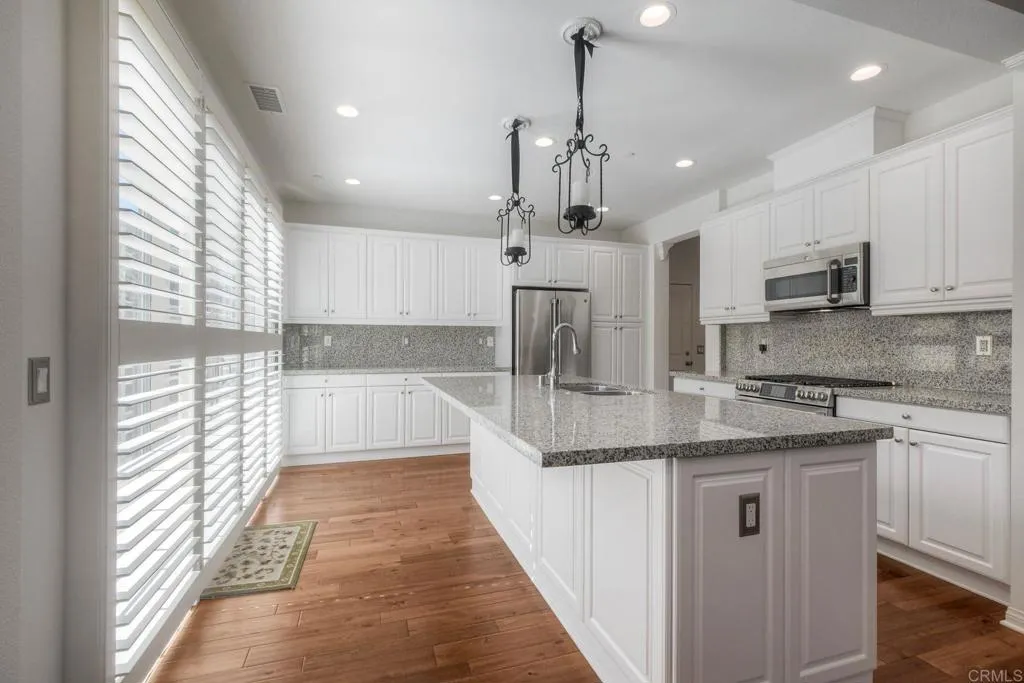 4302 Pacifica Way, Unit 2 Oceanside, NY 11572 - Photo 15 of 51 a large kitchen with stainless steel appliances kitchen island granite countertop a sink a counter space appliances and cabinets