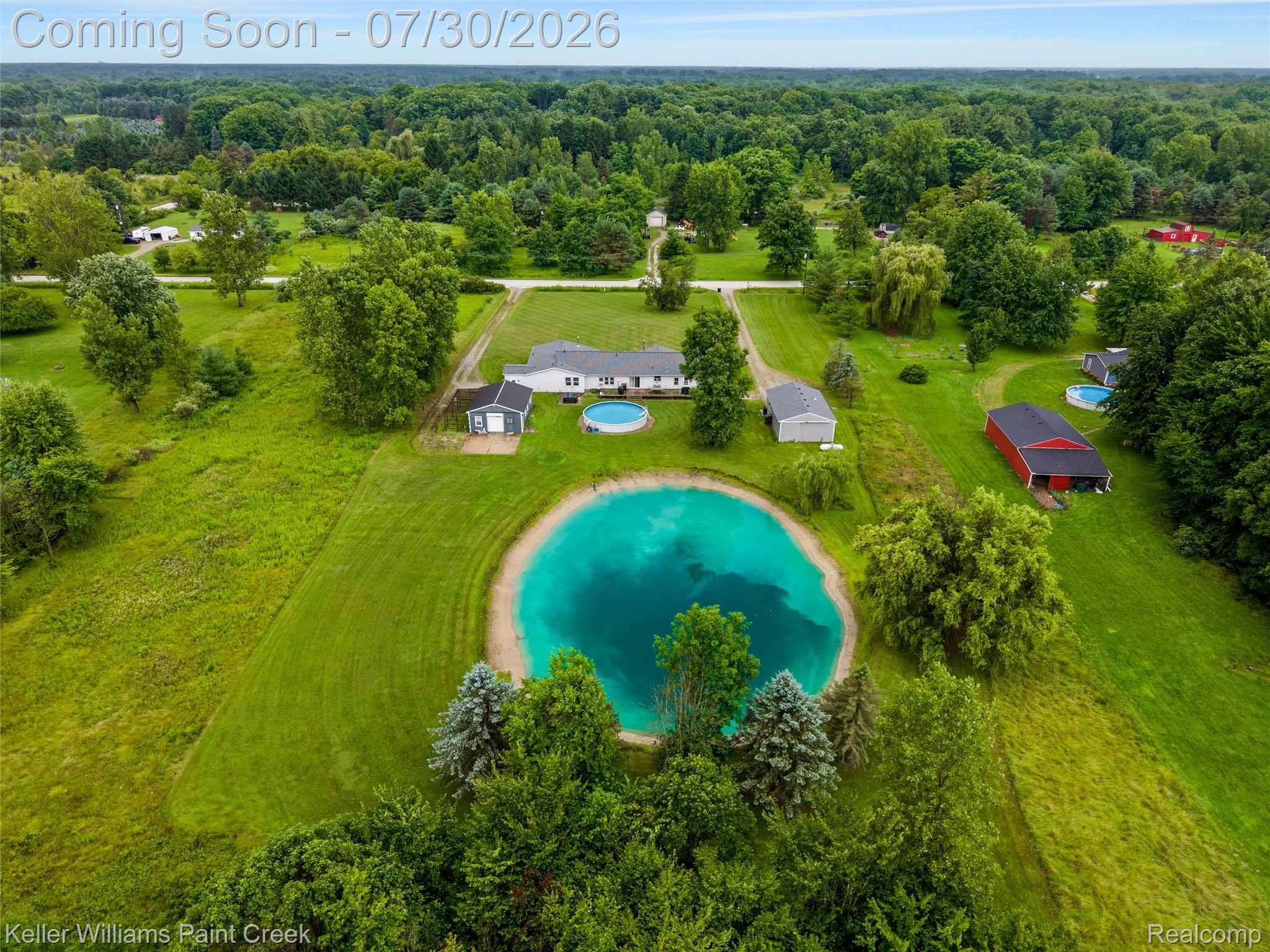 7544 Ravenswood Road Goodells, MI 48027 - Photo 30 of 42 Expansive property featuring a large pond, an above-ground swimming pool, a main residence, a detached garage, and a red barn