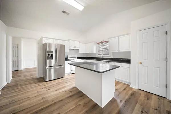 a kitchen with stainless steel appliances granite countertop a sink stove and refrigerator