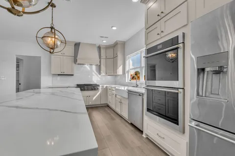 a large kitchen with a large window stainless steel appliances and cabinets