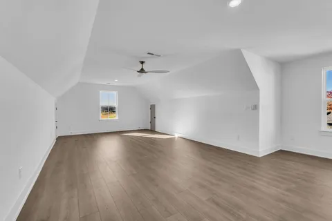 an empty room with windows and fireplace