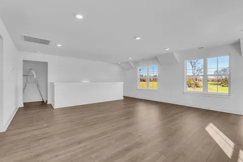 a view of an empty room with a fireplace and a window