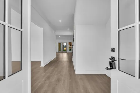 a view of a hallway with wooden floor and a living room