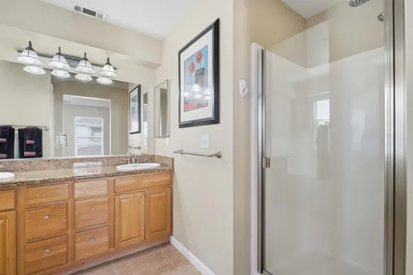 a spacious bathroom with a granite countertop sink a mirror and a shower