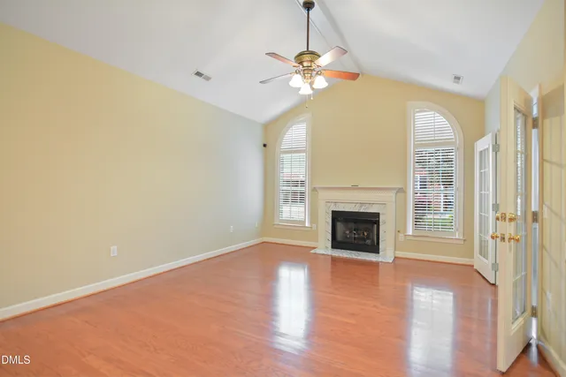 a view of a livingroom with a fireplace wooden floor and chandelier