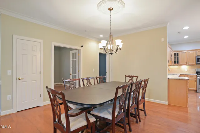 a view of a dining room with furniture a chandelier and wooden floor