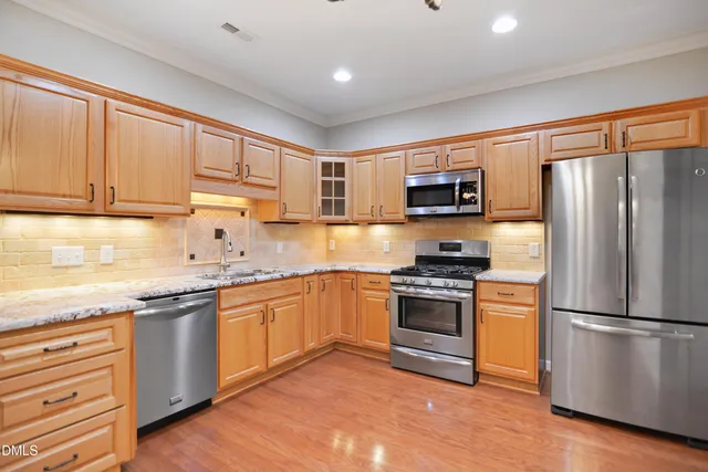 a kitchen with granite countertop stainless steel appliances and wooden cabinets