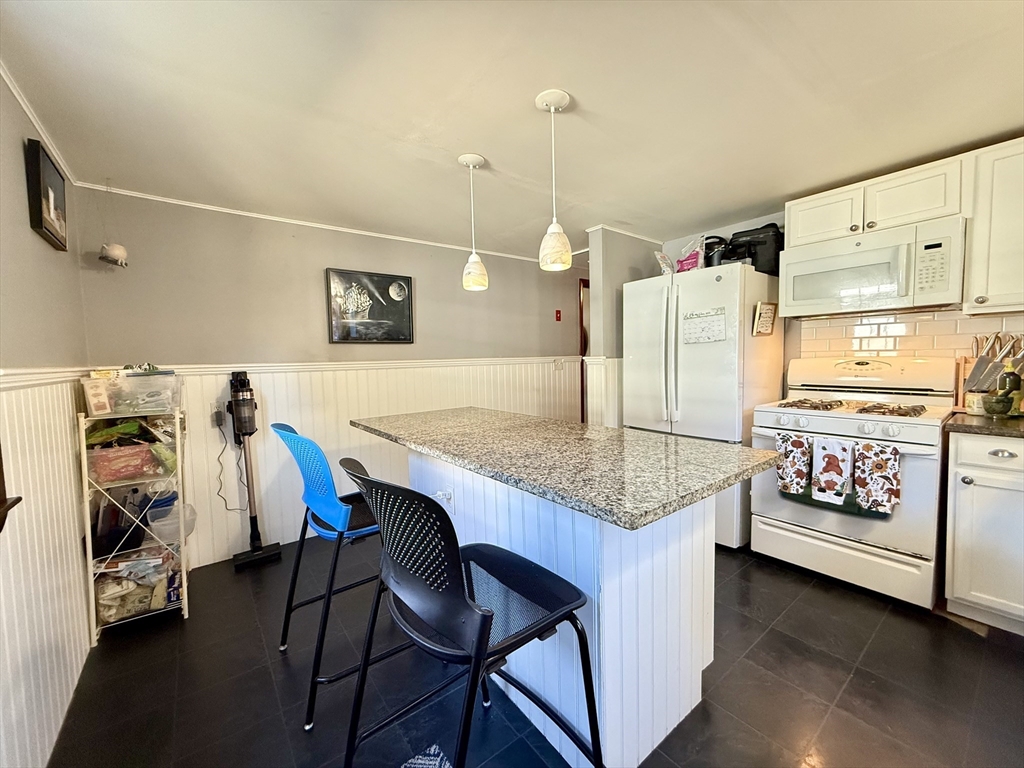 23 Circuit Road North Yarmouth, MA 02673 - Photo 12 of 34 a kitchen with a table chairs and a stove