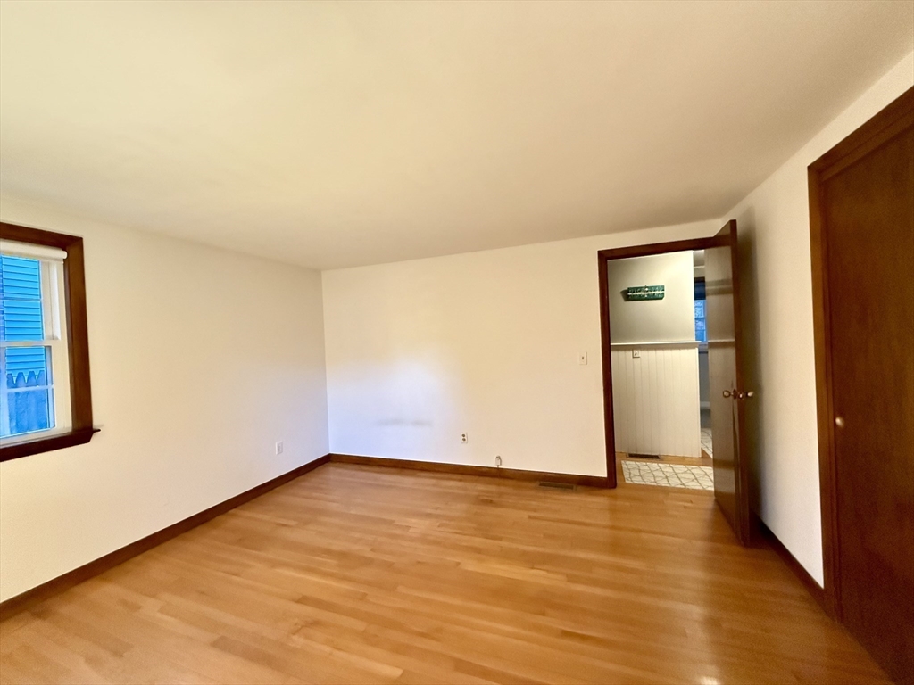 23 Circuit Road North Yarmouth, MA 02673 - Photo 20 of 34 an empty room with wooden floor and a kitchen