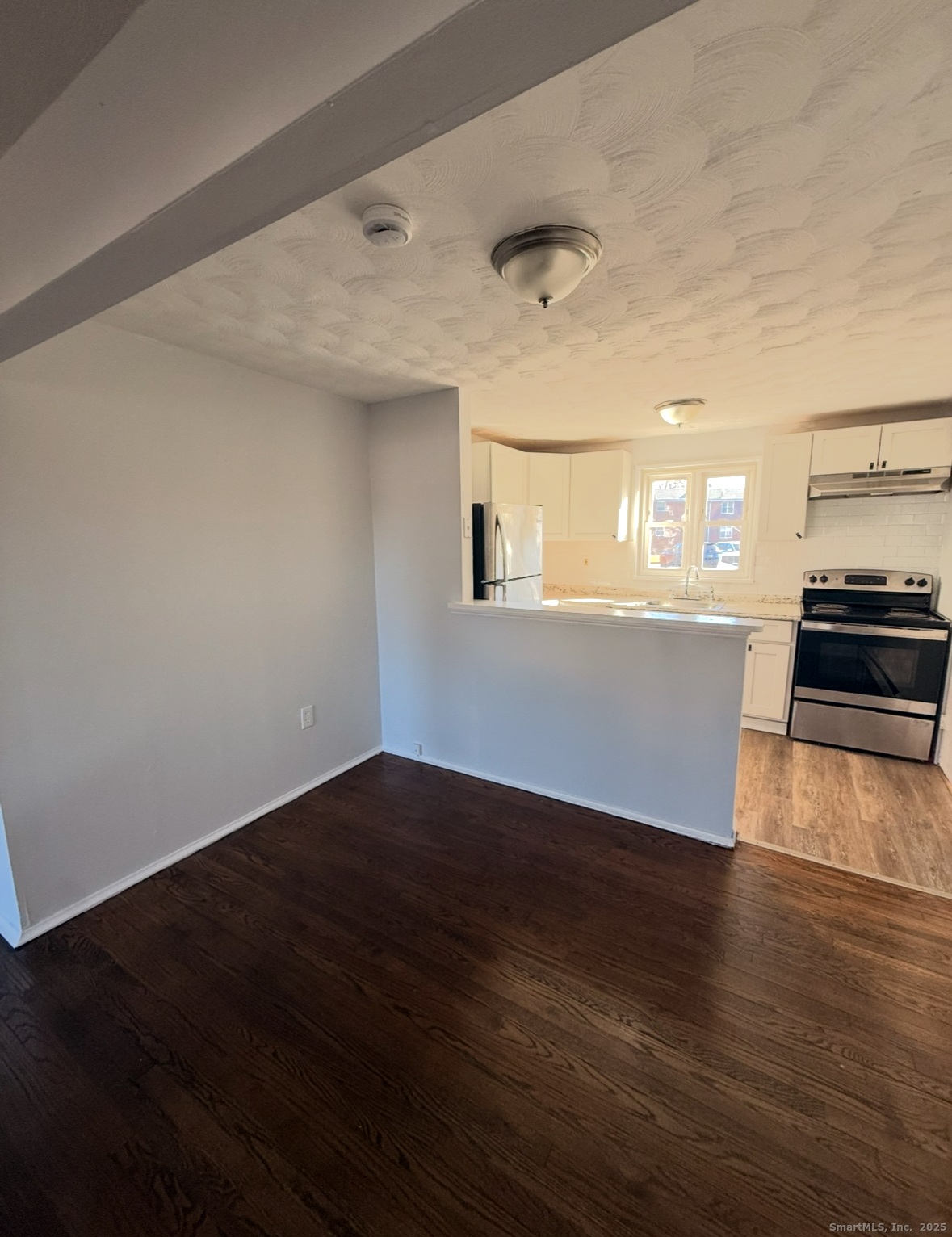 1275 Quinnipiac Avenue, Unit 9 New Haven, CT 06513 - Photo 6 of 6 an empty room with wooden floor and kitchen view