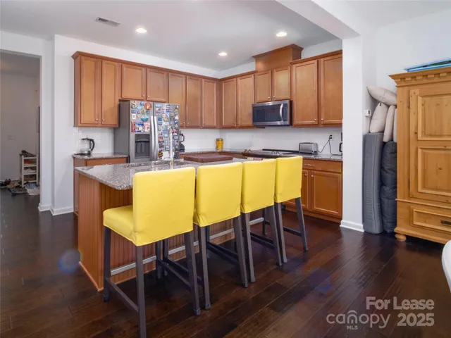 a kitchen with kitchen island granite countertop wooden floors and stainless steel appliances