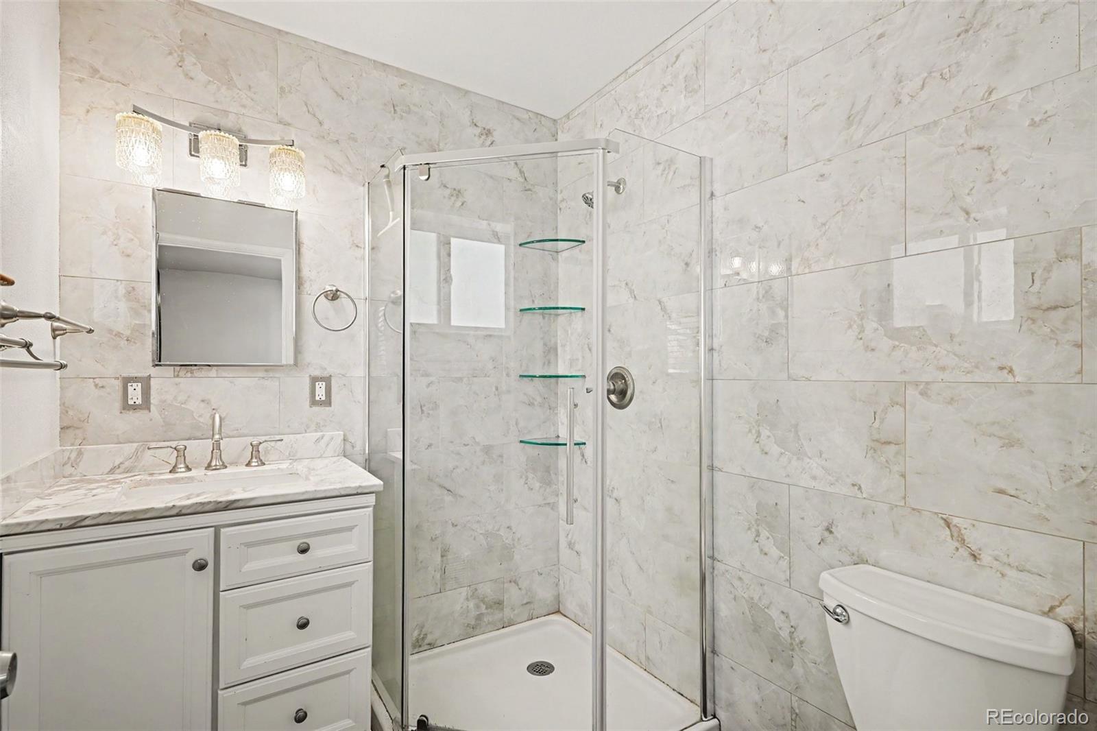 3217 South Stuart Street Denver, CO 80236 - Photo 23 of 29 a bathroom with a sink a toilet and shower