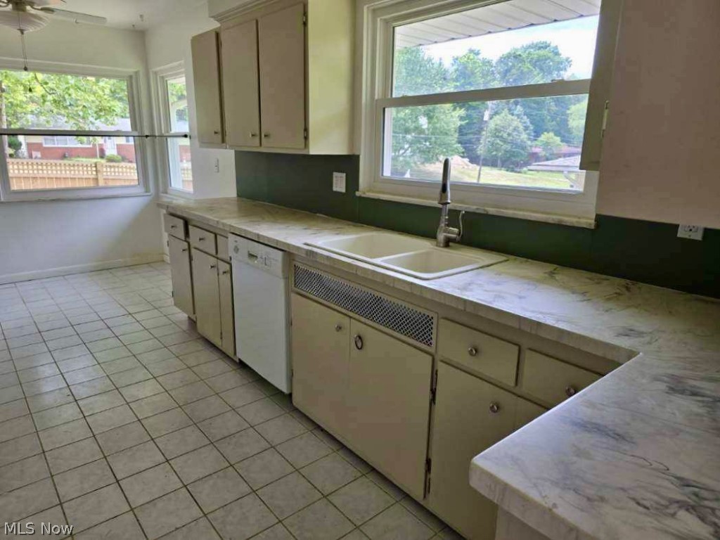 7735 Ragall Parkway Cleveland, OH 44130 - Photo 20 of 32 Kitchen with light tile patterned floors, white dishwasher, sink, and a wealth of natural light