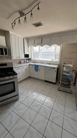 a kitchen with a sink a stove and lots of cabinets