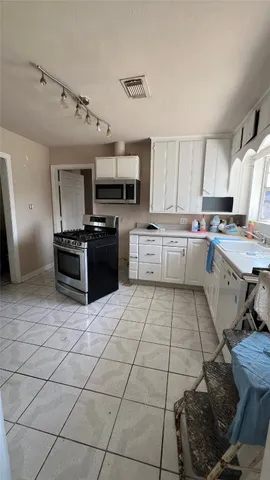a kitchen with a sink a stove and cabinets